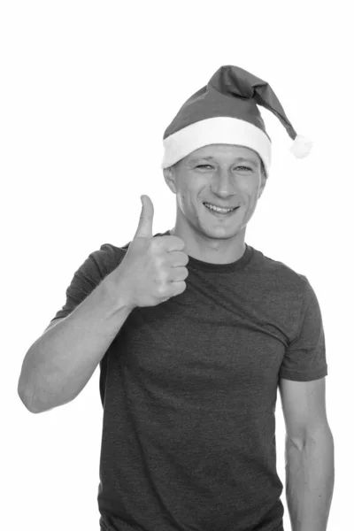 Студийный снимок молодого красивого белого мужчины, готового к Рождеству, показывающего большой палец на белом фоне — стоковое фото