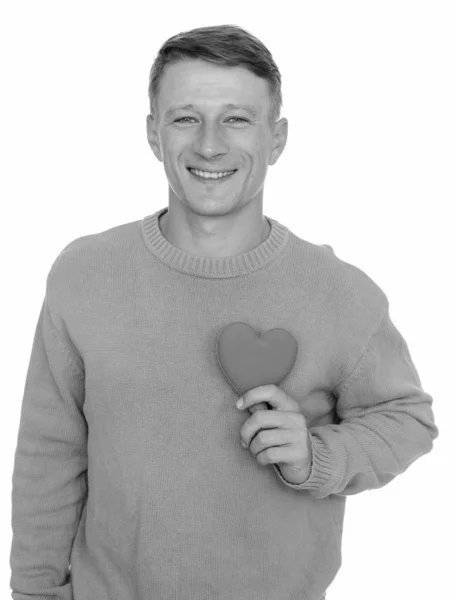 Estudio disparo de joven feliz hombre caucásico listo para el día de San Valentín sosteniendo corazón rojo aislado sobre fondo blanco — Foto de Stock