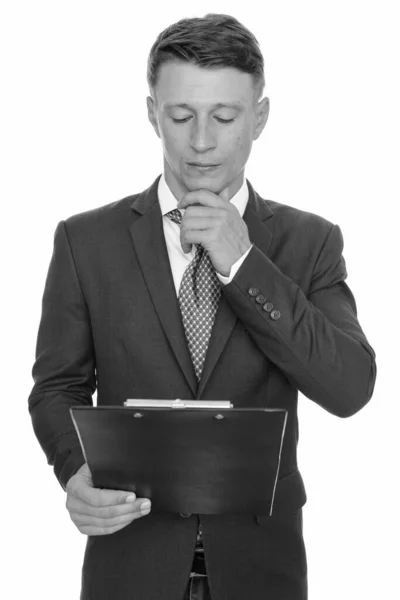 Studio shot de jeune homme d'affaires caucasien beau lecture presse-papiers et la pensée — Photo