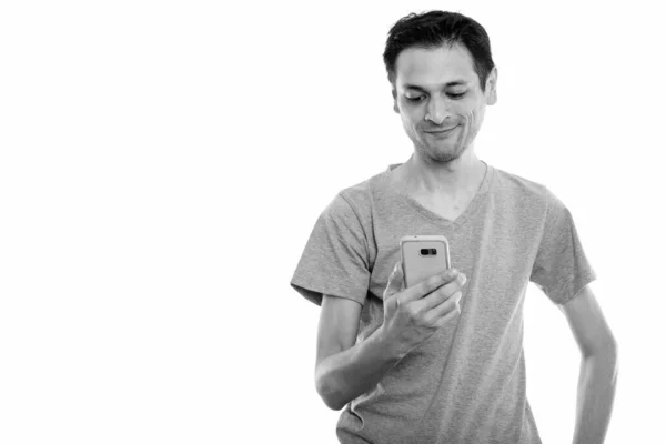 Strzał studio szczęśliwy młody człowiek uśmiechający się przy użyciu telefonu komórkowego — Zdjęcie stockowe
