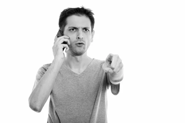 Stúdió lövés dühös fiatalember mutató ujj, rövid idő beszélő-ra mozgatható telefon — Stock Fotó