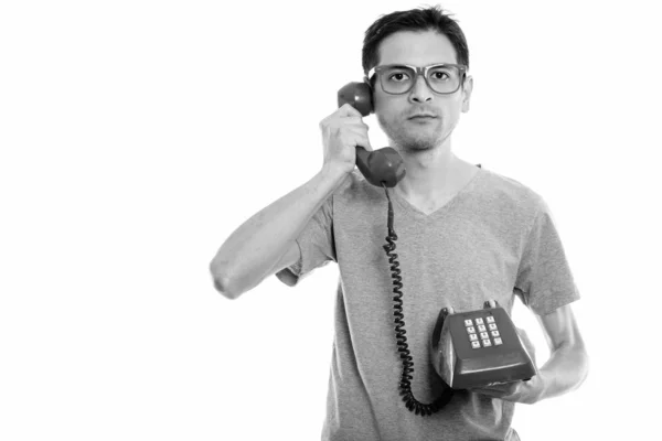 Estudio de disparo de un hombre joven con gafas mientras habla por teléfono viejo — Foto de Stock