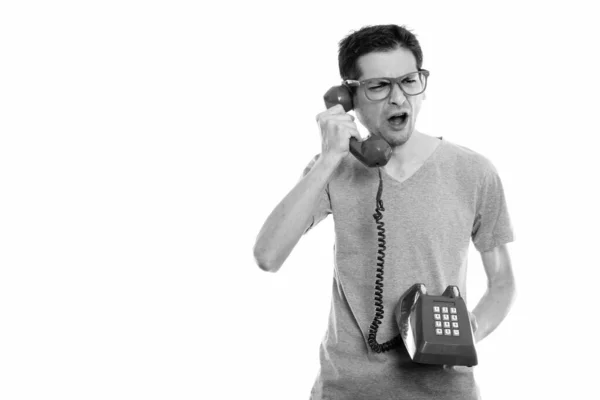 Estúdio tiro de jovem irritado falando no telefone antigo — Fotografia de Stock