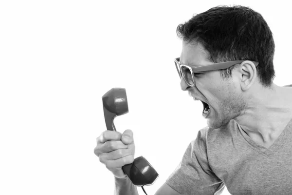 Close up of angry young man shouting at old telephone — Stock Photo, Image