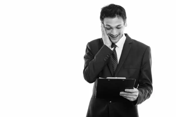 Estudio de disparo de joven empresario feliz sonriendo mientras lee en el portapapeles — Foto de Stock