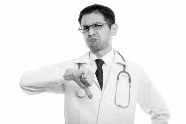 Studio shot de jeune homme médecin portant des lunettes tout en donnant pouce vers le bas — Photo