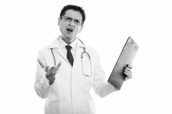 Estudio de hombre joven enojado médico sosteniendo portapapeles con el brazo levantado — Foto de Stock