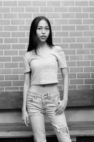 Молодих красивих азіатських Дівчинка-підліток стоячи проти цегляна стіна — стокове фото
