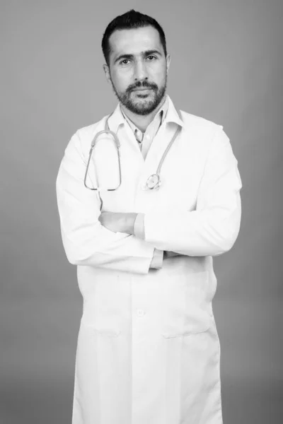 Guapo barbudo médico hombre persa contra fondo gris —  Fotos de Stock