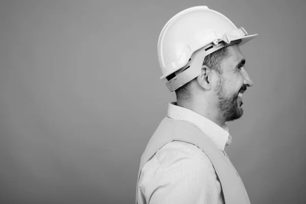 Guapo barbudo hombre persa trabajador de la construcción sobre fondo gris — Foto de Stock