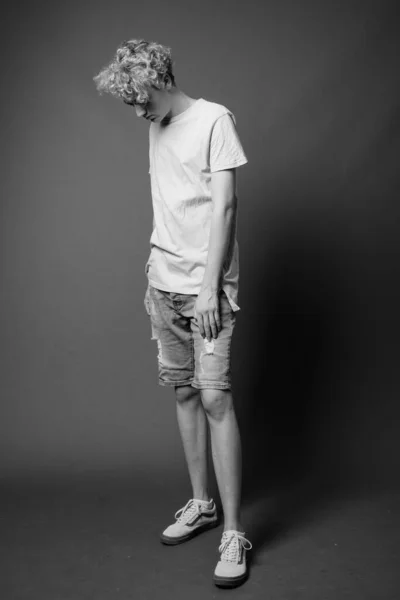 Skinny ung man med lockigt hår i svart och vitt — Stockfoto