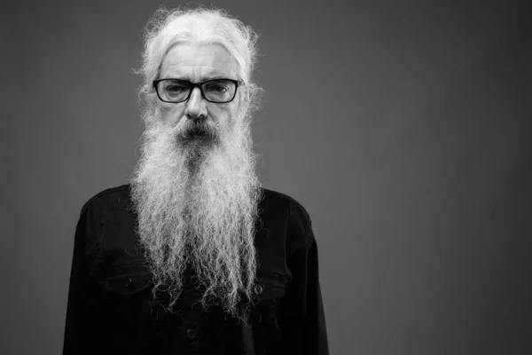 Старший мужчина с длинными волосами и бородой в черно-белом — стоковое фото