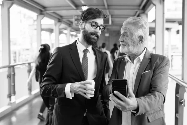 Multi ethnic bearded businessmen together around the city