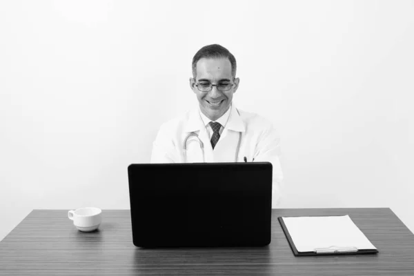 Reife persische Mann Arzt hinter Schreibtisch in schwarz und weiß — Stockfoto
