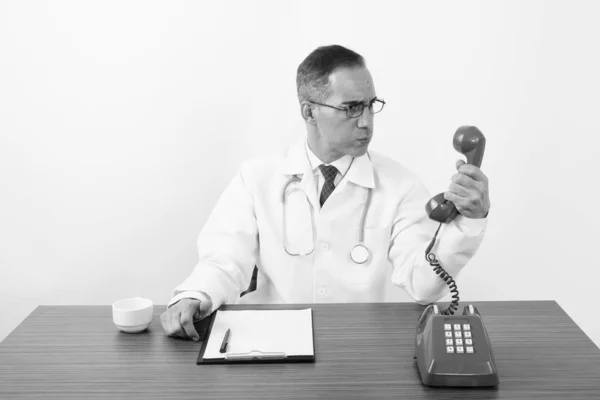 Médico hombre persa maduro detrás del escritorio en blanco y negro — Foto de Stock