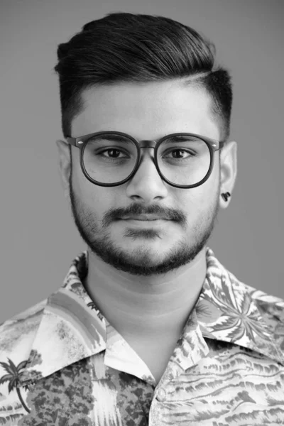 スタジオショットの若いですハンサムなひげを生やしたインドの観光客の男に対して白背景で黒と白 — ストック写真