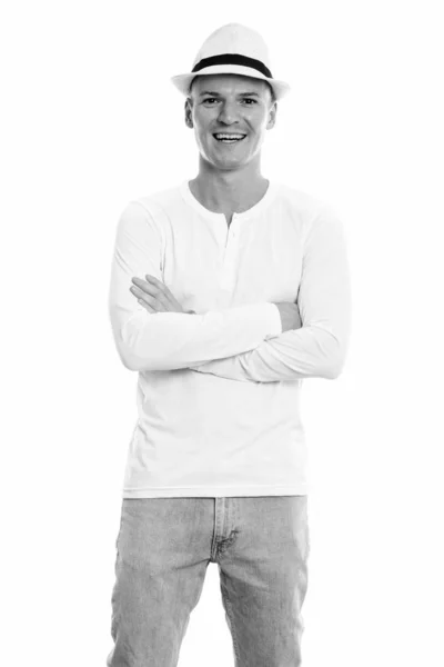 Studio shot of young happy man smiling and standing with arms crossed — Stock Photo, Image