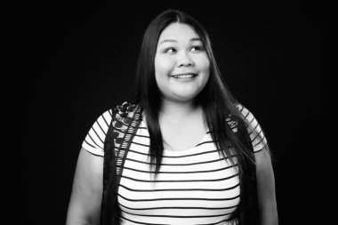 Siyah ve beyaz arka planda güzel şişman Asyalı kadının stüdyo çekimi