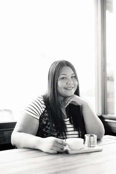 Beautiful overweight Asian woman relaxing at the coffee shop — Stock fotografie