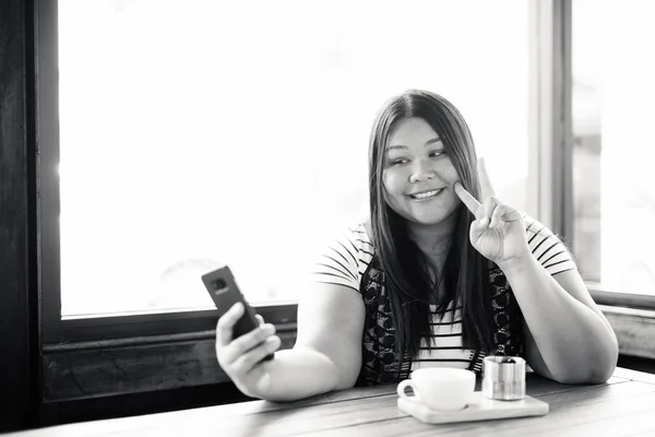 Beautiful overweight Asian woman relaxing at the coffee shop — Stock fotografie