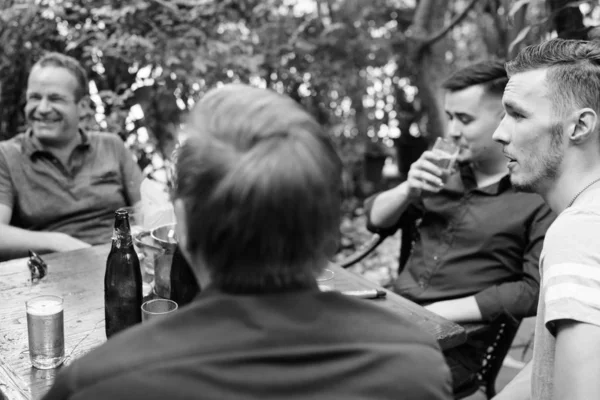 Group of men hanging out and relaxing together in the backyard