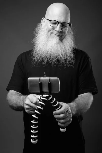 Volwassen kale man met lange baard vlogging met telefoon — Stockfoto