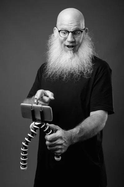 Mature bald man with long beard vlogging with phone — Stock Photo, Image