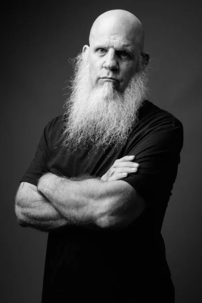 Mature bald man with long white beard in black and white