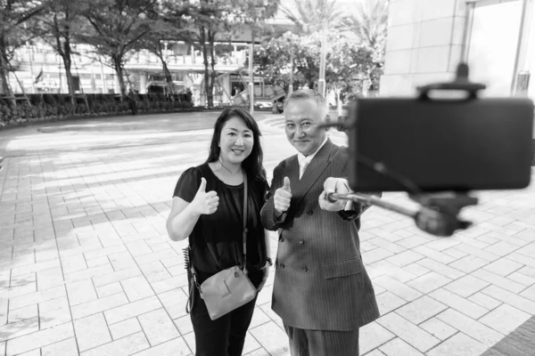 Mature homme d'affaires asiatique et mature femme asiatique explorer la ville ensemble — Photo