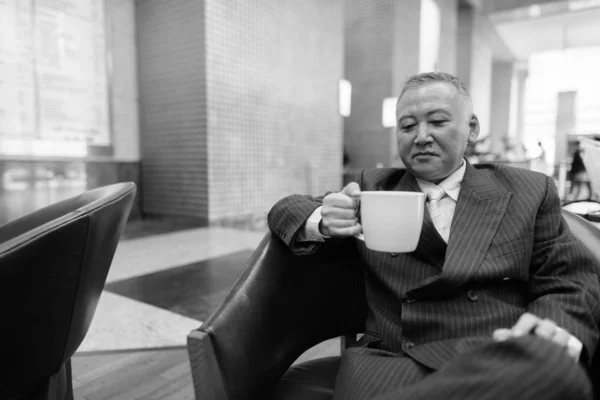 Mature Asian businessman relaxing inside the coffee shop — Stock Photo, Image