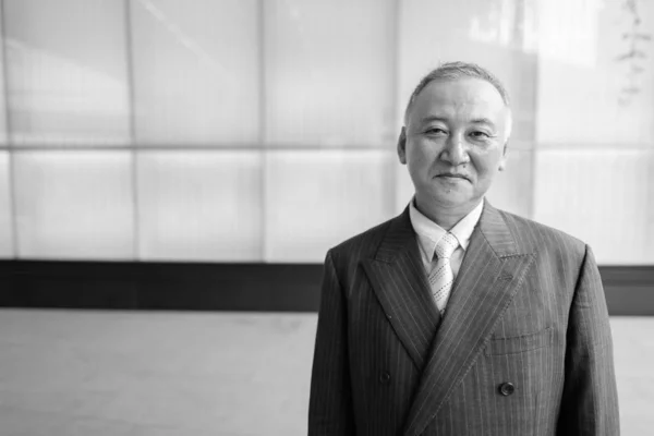 Portret van volwassen Aziatische zakenman verkennen rond de stad — Stockfoto
