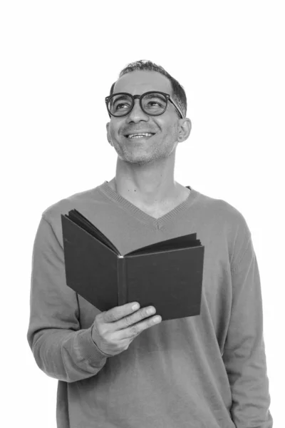 Mature happy Persian man holding book while thinking — Stock Photo, Image