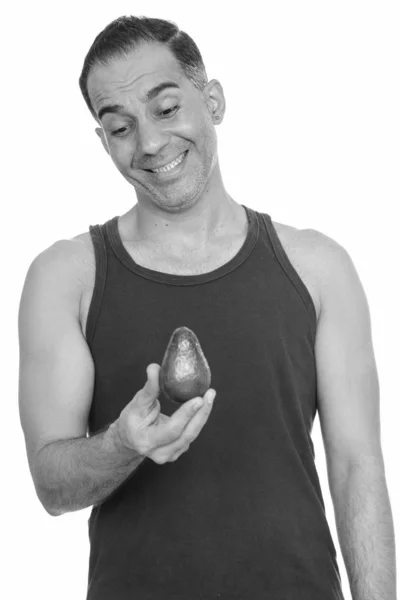 Mature happy Persian man holding avocado in black and white — Stock Photo, Image