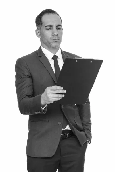 Maduro guapo persa hombre de negocios leyendo en portapapeles en blanco y negro — Foto de Stock