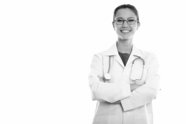 Estudio de la joven mujer feliz médico sonriendo mientras lleva gafas con los brazos cruzados —  Fotos de Stock