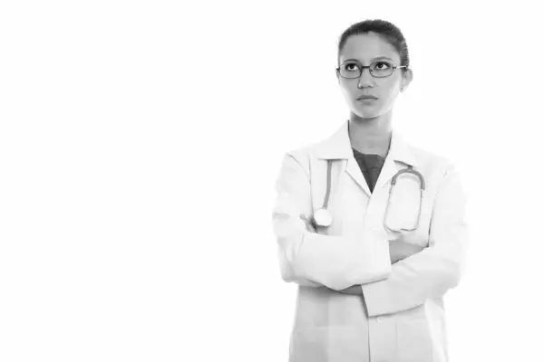 Estúdio tiro de jovem mulher bonita médico pensando ao usar óculos com braços cruzados — Fotografia de Stock