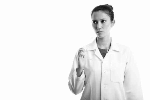 Estúdio tiro de jovem mulher bonita médico segurando óculos de proteção ao pensar — Fotografia de Stock