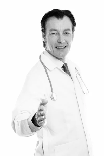 Studio colpo di maturo felice uomo medico sorridente mentre dà stretta di mano — Foto Stock