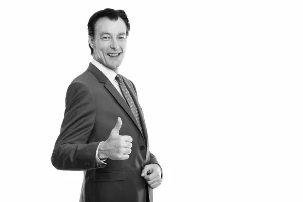 Studio shot of mature happy businessman smiling and giving thumb up — Stock Photo, Image