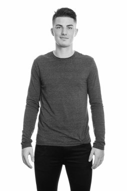 Siyah beyaz arka planda izole edilmiş yakışıklı bir gencin stüdyo fotoğrafı.