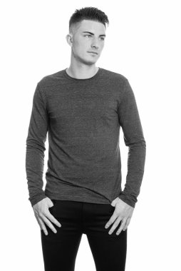 Siyah beyaz arka planda izole edilmiş yakışıklı bir gencin stüdyo fotoğrafı.