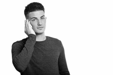 Siyah beyaz arka planda izole edilmiş yakışıklı bir gencin stüdyo fotoğrafı.