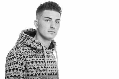 Kapüşonlu genç ve yakışıklı bir adamın, siyah beyaz arka planda izole edilmiş bir fotoğrafı.