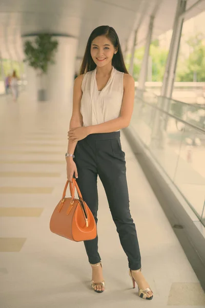 Jong mooi aziatisch zakenvrouw opknoping uit bij de voetgangersbrug — Stockfoto
