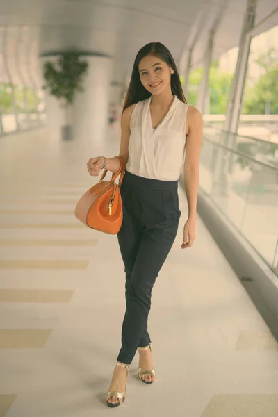 Молода приваблива азіатська комерсантка, що висить біля пішохідного мосту — стокове фото