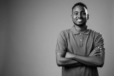 Siyah-beyaz gri arka planda Afrikalı genç bir adamın stüdyo çekimi.