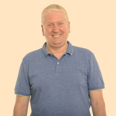Studio shot of mature man isolated against yellow background