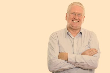 Studio shot of mature man isolated against yellow background
