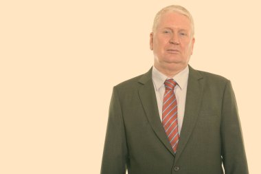 Studio shot of mature man isolated against yellow background