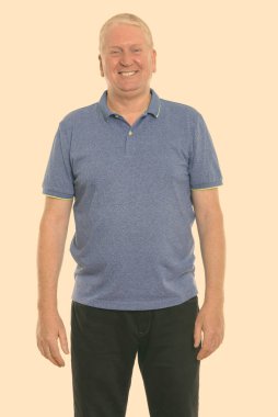 Studio shot of mature man isolated against yellow background